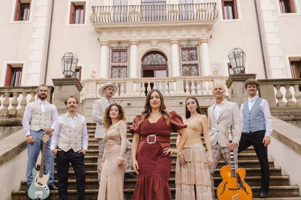 Aba Chiara e la sua formazione musicale posano su una scalinata di una villa storica, proposta artistica per eventi di lusso in location esclusive